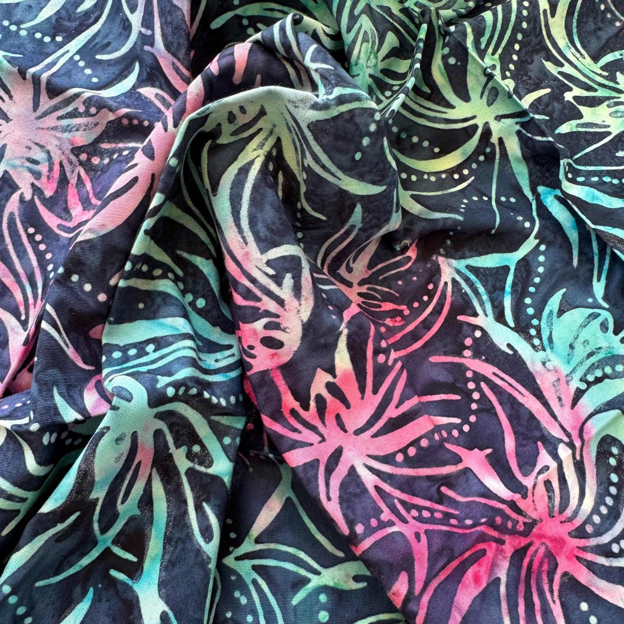 Tela batik hojas tropicales monstera verde menta y rosa sobre negro